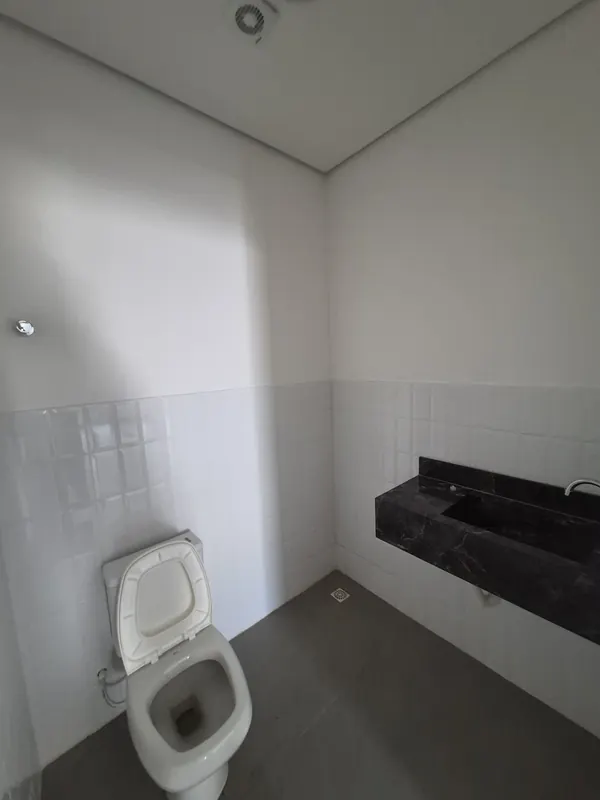 Banheiro privativo com bancada em pedra escura