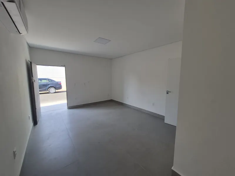 Interior de sala com porta para a rua, ar-condicionado e piso porcelanato