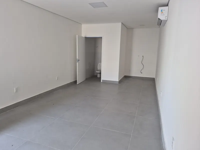 Sala com o banheiro privativo aberto ao fundo